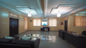 A spacious living room with a flat-screen TV, a coffee table, and a sofa. - Private Home Lodge (Accra)