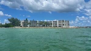 A beachfront hotel with multiple balconies, a pool area, and a view of the ocean. - Incredible Gulf-front 2 bed 2 bath condo with unbeatable views in Pass-A-Grille. (St. Pete Beach)