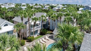 A residential area with multiple houses, a swimming pool, and palm trees. - Cap`s Cottage: Upscale Retreat-Walk to Beach+Pool (Destin)