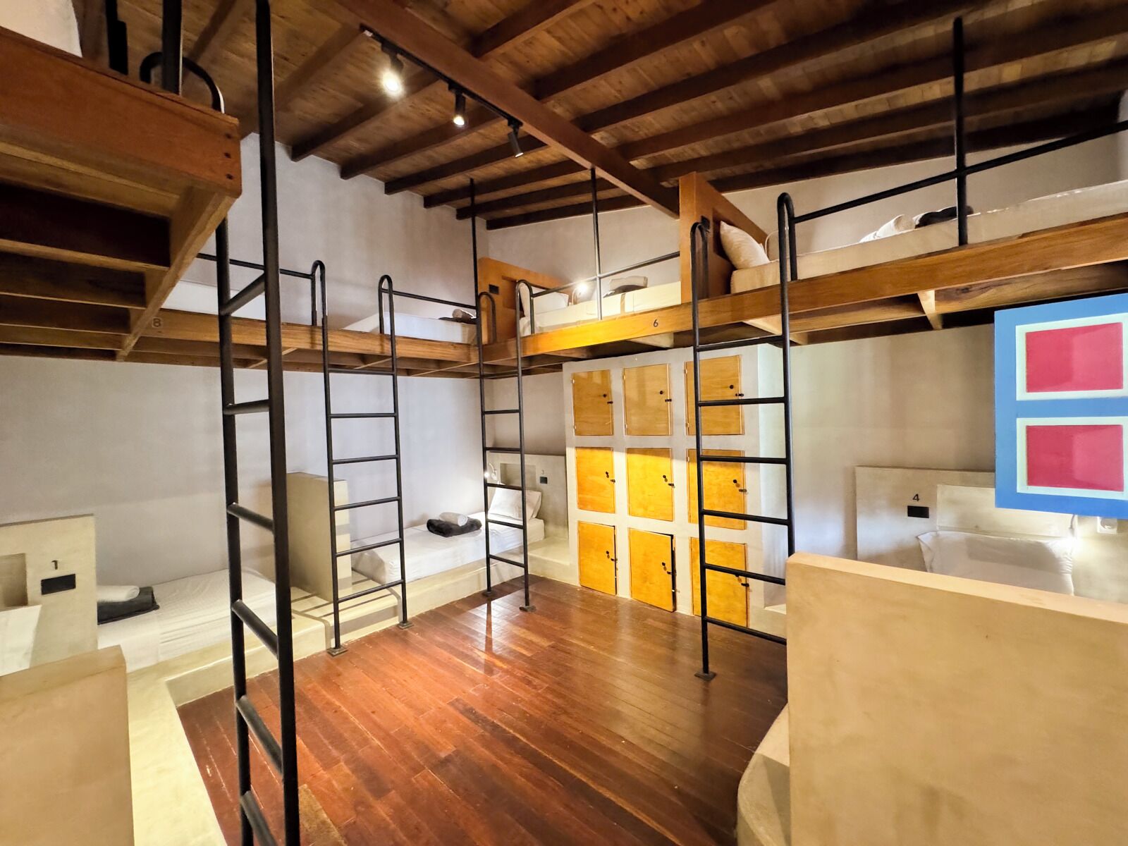 Un espacio tipo loft con vigas de madera y literas.
