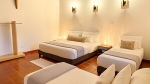 A hotel room with two beds, a bedside table with a lamp, and a standing lamp on the wall. - Dreamer Cocora (Salento)