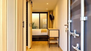 A hotel room with a bed, a small table, a TV, and a sliding door. - Casa Marina (Querétaro)