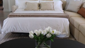 A bedroom with a bed, a nightstand, a coffee table with a vase of flowers, and a sofa. - Modern Waterfront home w/ Game Room & Private Dock (Cape Coral)