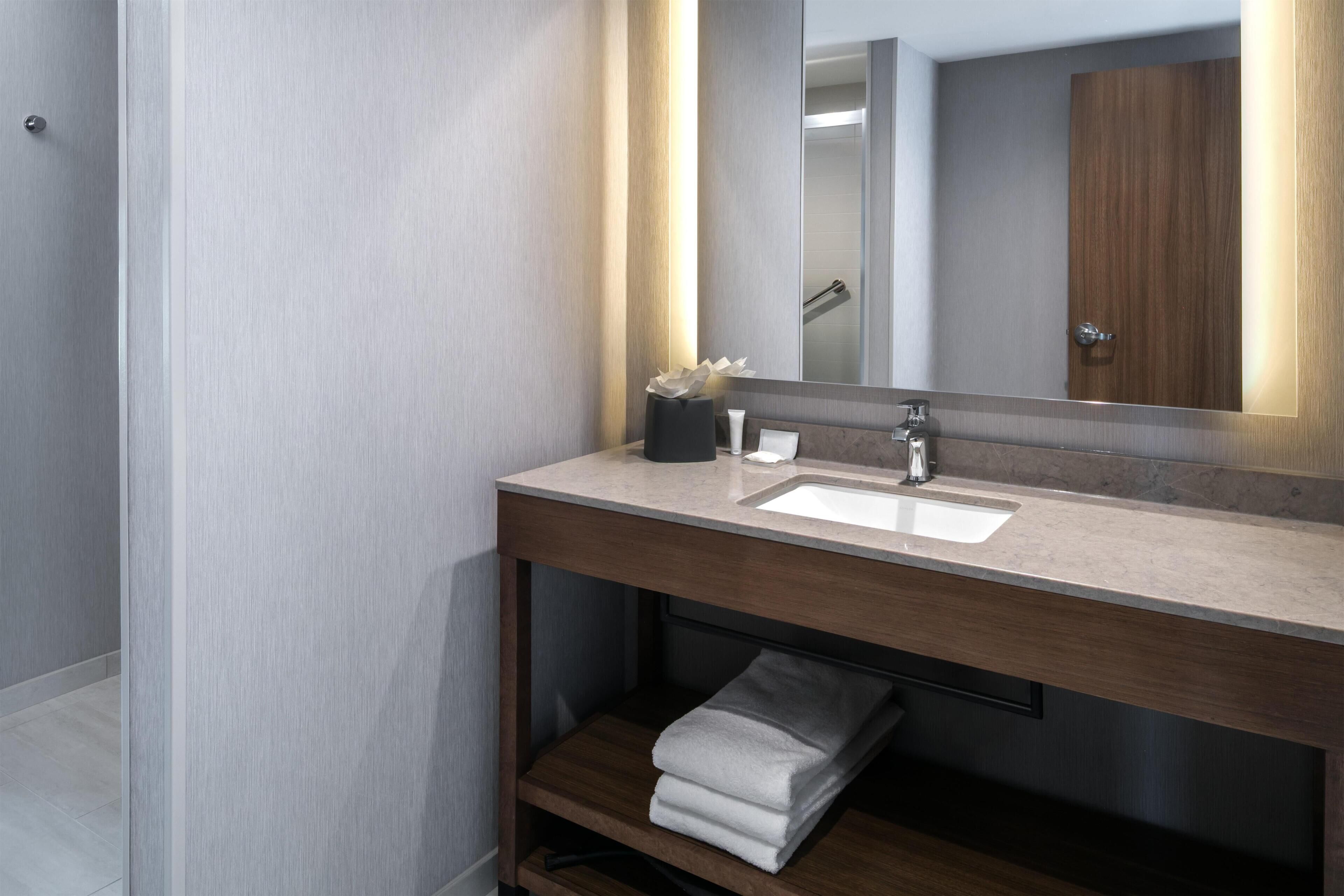 A modern bathroom with a vanity, sink, and mirror.