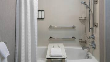 A modern bathroom with a bathtub, a shower, and a towel rack.