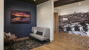 A modern interior with a sofa, a small table, a patterned rug, and a large wall mural.