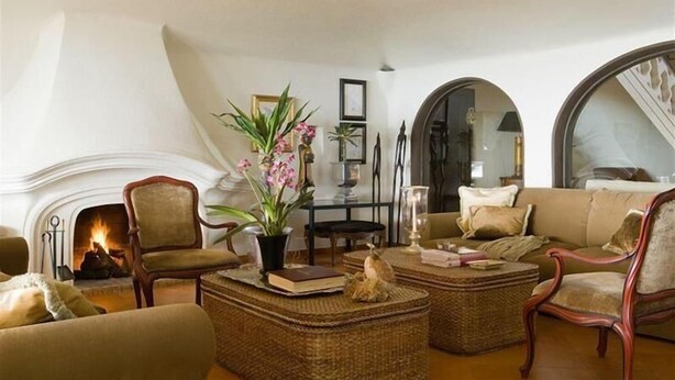 Una sala de estar acogedora con chimenea, asientos cómodos y plantas decorativas.
