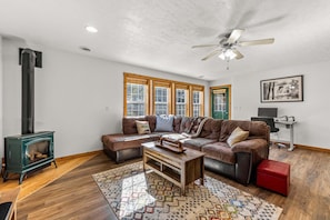 A living room with a fireplace, a sofa, a coffee table, and a patterned rug.