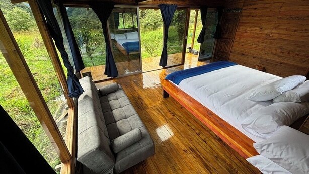 Un dormitorio con cama, sofá y vistas al exterior.