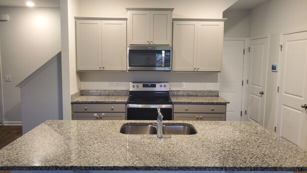 A kitchen with granite countertops, a stainless steel sink, a microwave, and a stove. - Room with private bathroom for rent for long periods. (Pooler)