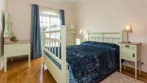 A bedroom with a bed, nightstands, a dresser, a window with curtains, and a mirror. - 11 Villa Coelho by Pechao (Olhao)