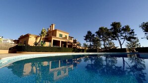 Une grande maison avec une piscine à l’avant.