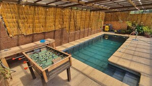 A pool area with a foosball table and a water filtration system. - CASA EL CANELO (El Quisco)