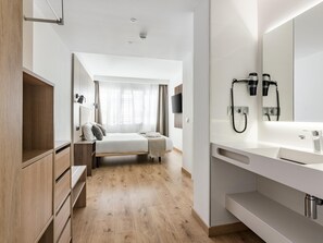A modern hotel room with a bed, bedside table, wardrobe, and a large mirror with a telephone. - Charming Eurobuilding 2 Splendid Madrid, Confort in the city (Madrid)