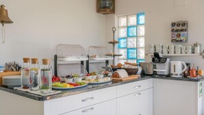 Une cuisine moderne dotée d’un bar pour prendre le petit-déjeuner, de divers produits alimentaires et d’un coin café.