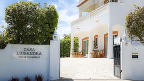 Un bâtiment blanc sur lequel on peut lire l’inscription « CASA LUISANDRA, chambre d’hôtes ».