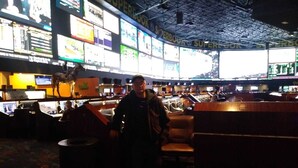 A large, dimly lit room with multiple screens displaying various content. - Las Vegas Formula 1 Weekend Nov21 2025 (Las Vegas)