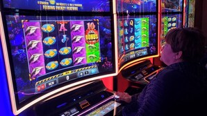 A person playing a slot machine with a dolphin theme. - Las Vegas Formula 1 Weekend Nov21 2025 (Las Vegas)
