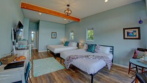 A bedroom with two beds, a TV, and a dining area. - Oceanfront Luxury Suite Overlooking Kachemak Bay and Homer Spit! (Homer)