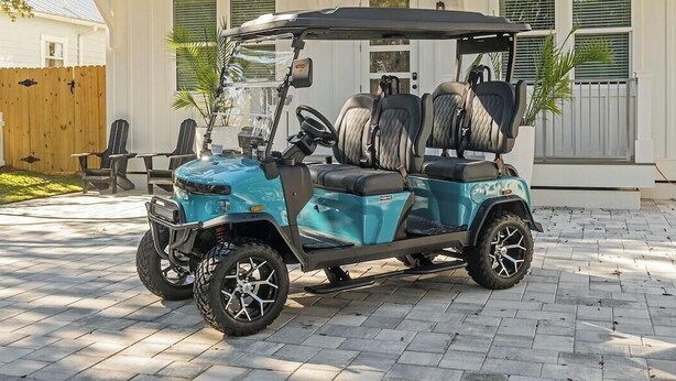 A golf cart parked on a paved driveway with a house in the background. - New Coastal Retreat | Spa & Pool + Beach Access (Destin)
