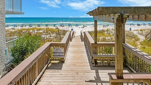 A wooden boardwalk leading to a beach with a clear sky. - New Coastal Retreat | Spa & Pool + Beach Access (Destin)