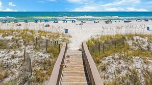 A wooden boardwalk leading to a beach with clear skies and calm waters. - New Coastal Retreat | Spa & Pool + Beach Access (Destin)