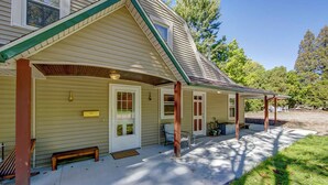 A two-story house with a covered porch, a front door, and a small front yard. - Lehr Court Cottage - Home in the Heart of Wooster (Wooster)