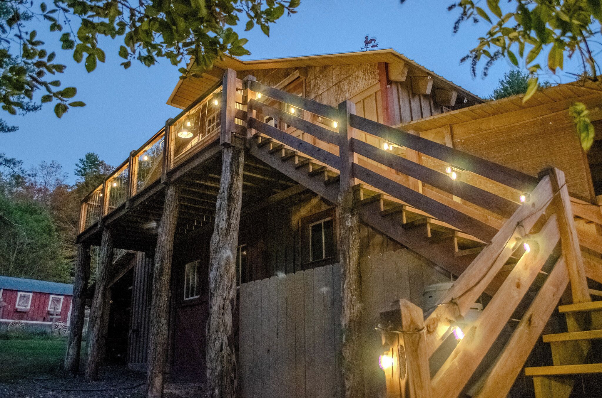 A wooden cabin with a wooden staircase leading to a balcony.