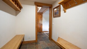 A hallway with wooden benches, a door leading to another room, and a wall-mounted picture. - Moonstone Lodge • Hot Tub • Spacious (Breckenridge)