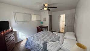 A bedroom with a bed, a desk, a chair, a television, and a ceiling fan. - Charming SE ICT Home 3 Bedrooms/2 Baths/2 Queens/1 Twin/1 Queen Pullout (Wichita)