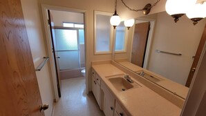 A bathroom with a large mirror, a sink, and a shower area. - Spacious 4-bedroom house in Los Altos (Los Altos)