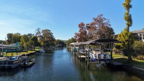 A canal with boats docked on the left and a covered boat ramp on the right.
