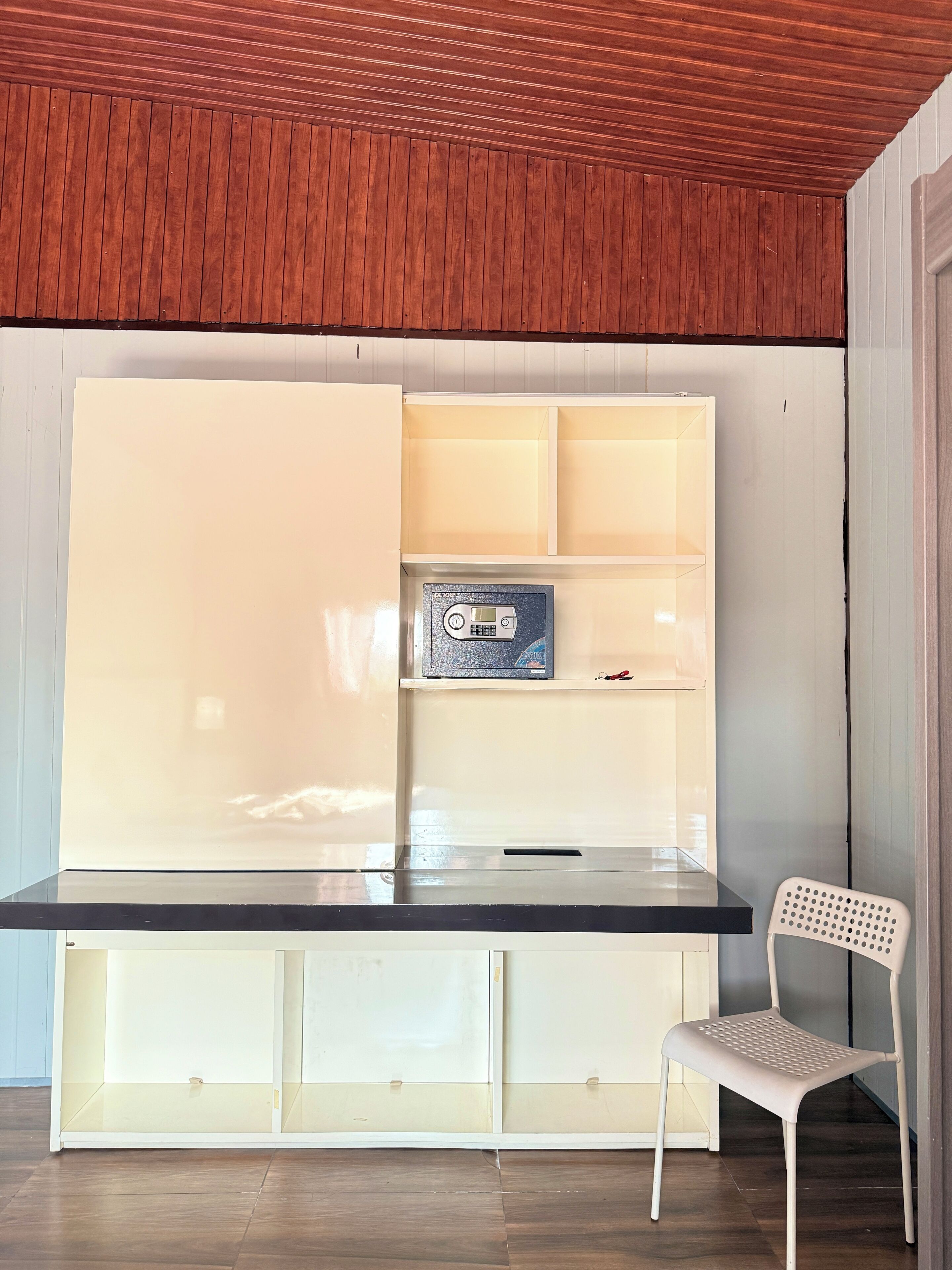 Une pièce comprenant un bureau intégré, une chaise et une radio.