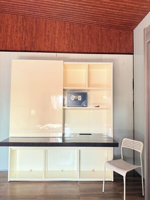 A room with a built-in desk, a chair, and a radio.