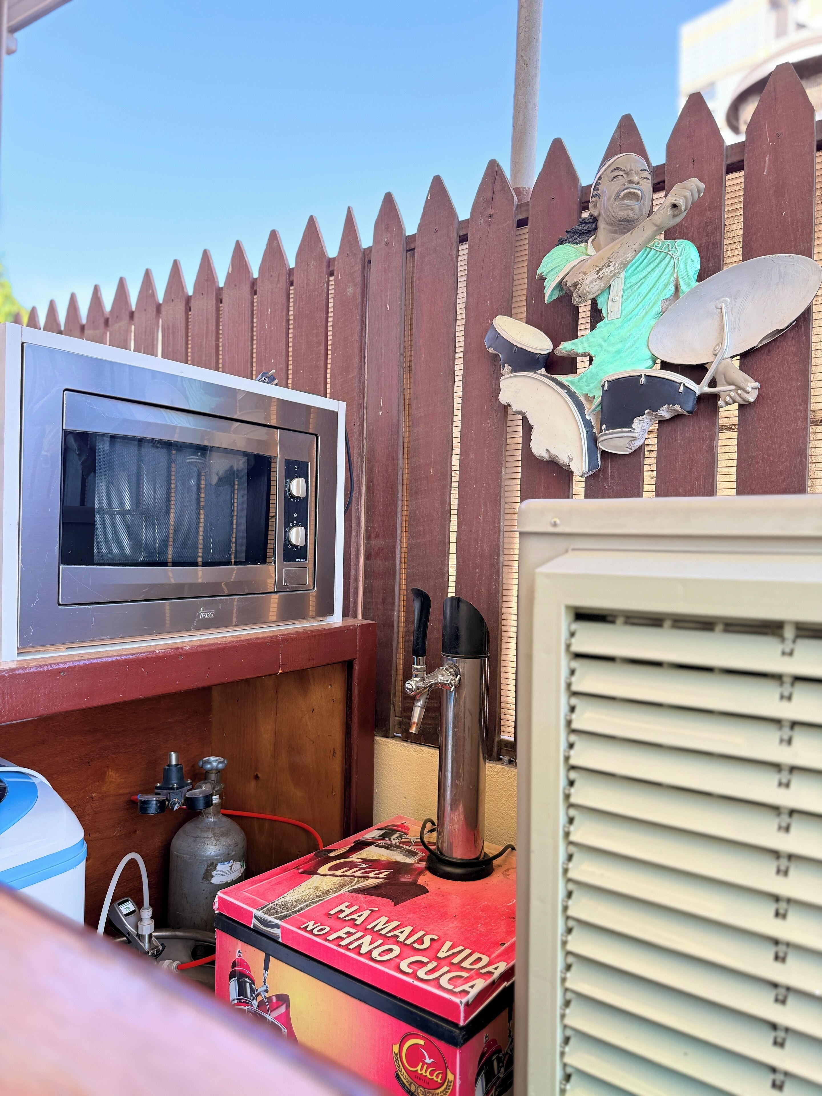 Un coin cuisine équipé d’un four à micro-ondes, d’une machine à café et d’un meuble en bois.