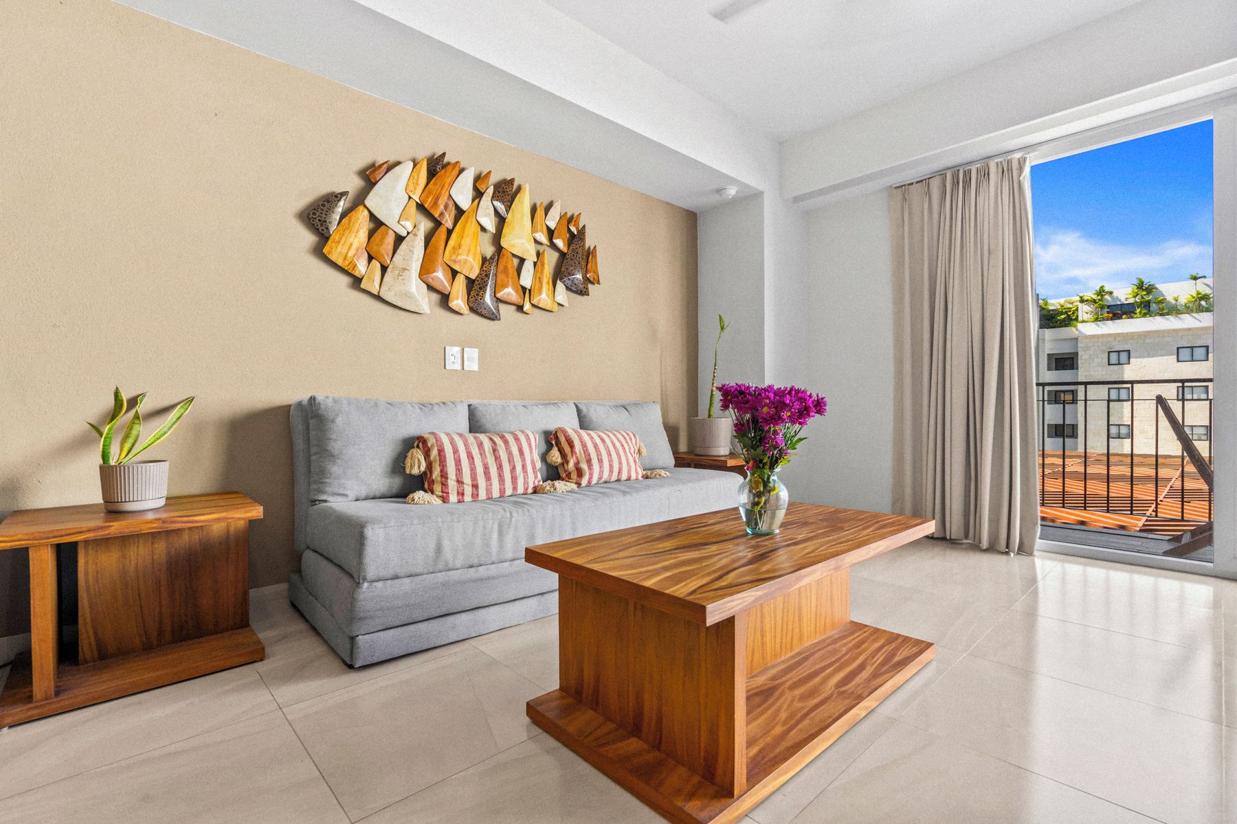 A modern living room with a grey sofa, wooden coffee table, and a wall art piece.