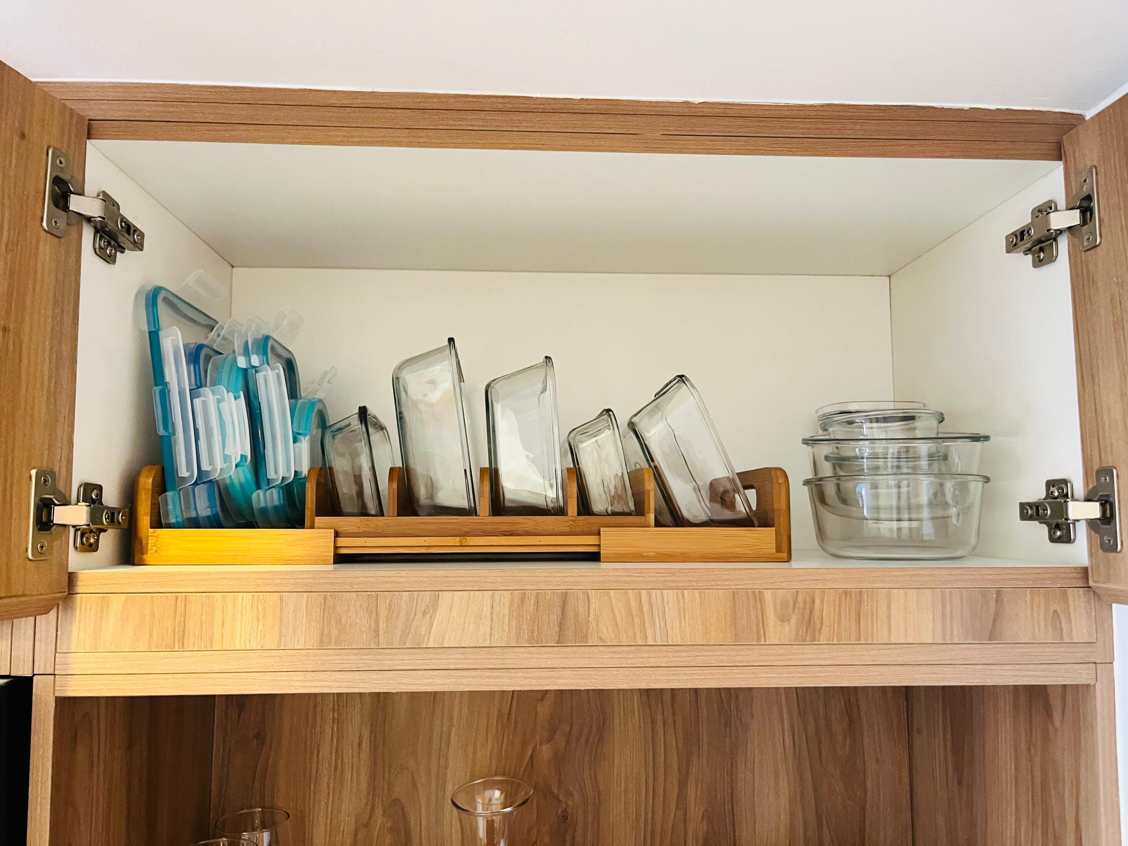 Un meuble en bois contenant un bocal en verre et une étagère sur laquelle sont posés plusieurs récipients en verre.