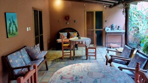A cozy patio area with a wooden ceiling, a round table with a floral tablecloth, and a sofa with patterned cushions. - Amazing Oasis 2-bedroom apartment in Centro Oaxaca de Juárez (Oaxaca de Juárez)