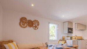 Una cocina moderna con armarios blancos, un microondas y una ventana sobre el fregadero.