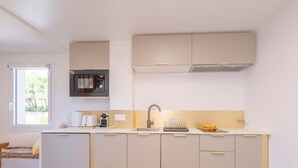 Una cocina moderna con microondas integrado, un lavamanos y una ventana.