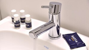 A modern bathroom sink with a chrome faucet and a bottle of hand soap labeled "KAVIA".