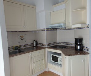 A compact kitchen with a microwave, coffee maker, and a sink. - Senhora Da Rocha (Lagoa)