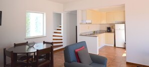 Un appartement moderne comprenant un coin repas, un salon et une cuisine.
