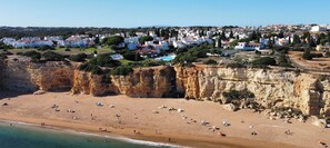 Une ville côtière dotée d’une plage, de falaises rocheuses et de bâtiments blancs.