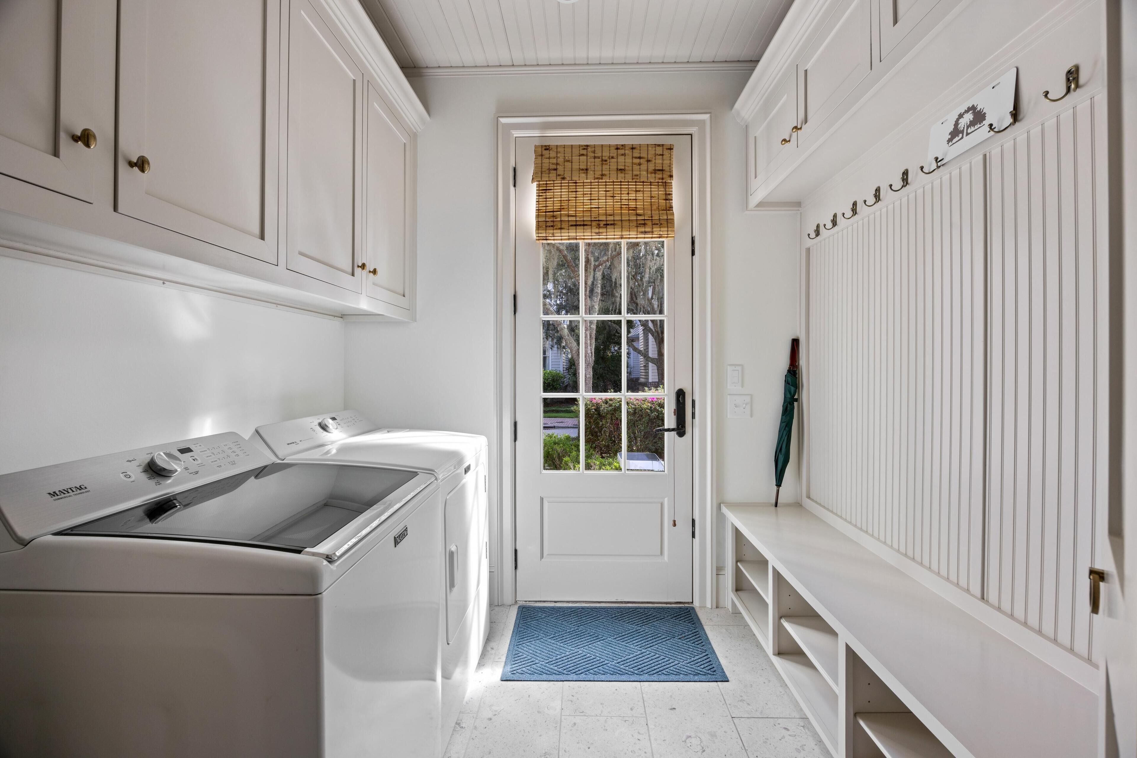 A laundry room with a washing machine, dryer, and a door with a window.