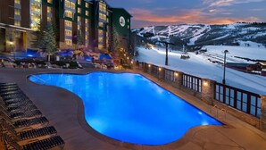 Ein Hotel mit einem großen Hallenbad, Skipisten im Hintergrund und Bergblick.