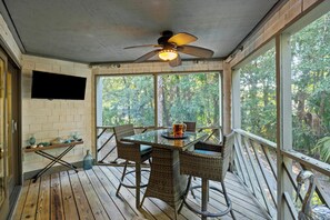 A covered outdoor area with a table and chairs, a ceiling fan, and a TV mounted on the wall. - Tennis View! Updated Villa! WALK TO TENNIS CENTER! Screened Porch! (Kiawah Island)