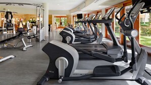 Une salle de sport équipée de tapis de course, d’appareils de musculation et de divers équipements d’exercice.