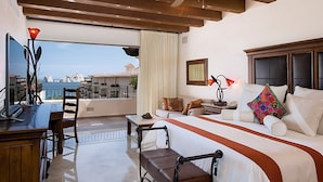 Une chambre d’hôtel avec un balcon, un lit, un bureau et un canapé.