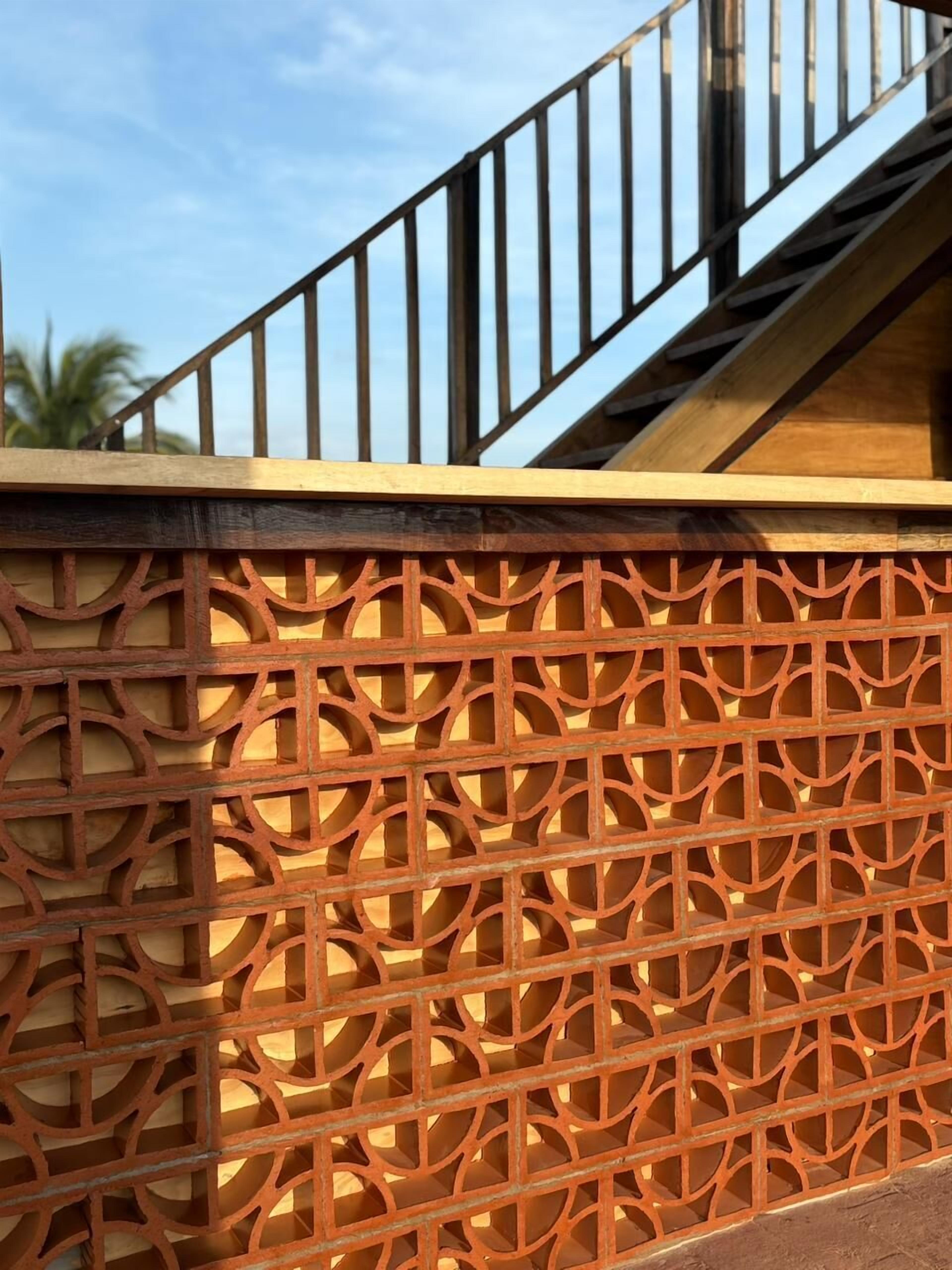 A staircase with a wooden railing and a decorative metal fence with geometric patterns.
